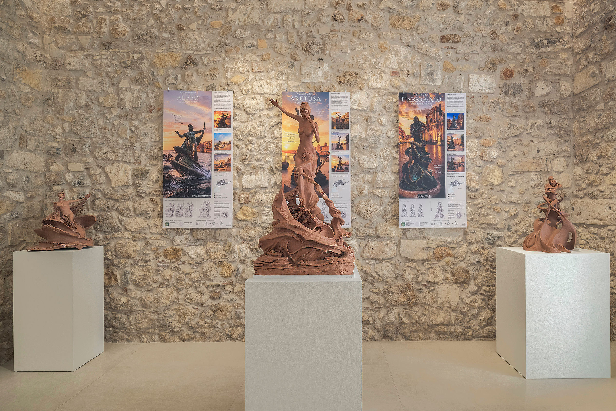 Tre sculture originali in argilla di Angelo Iozza davanti ai pannelli della proposta urbana di Kaleido Studio.